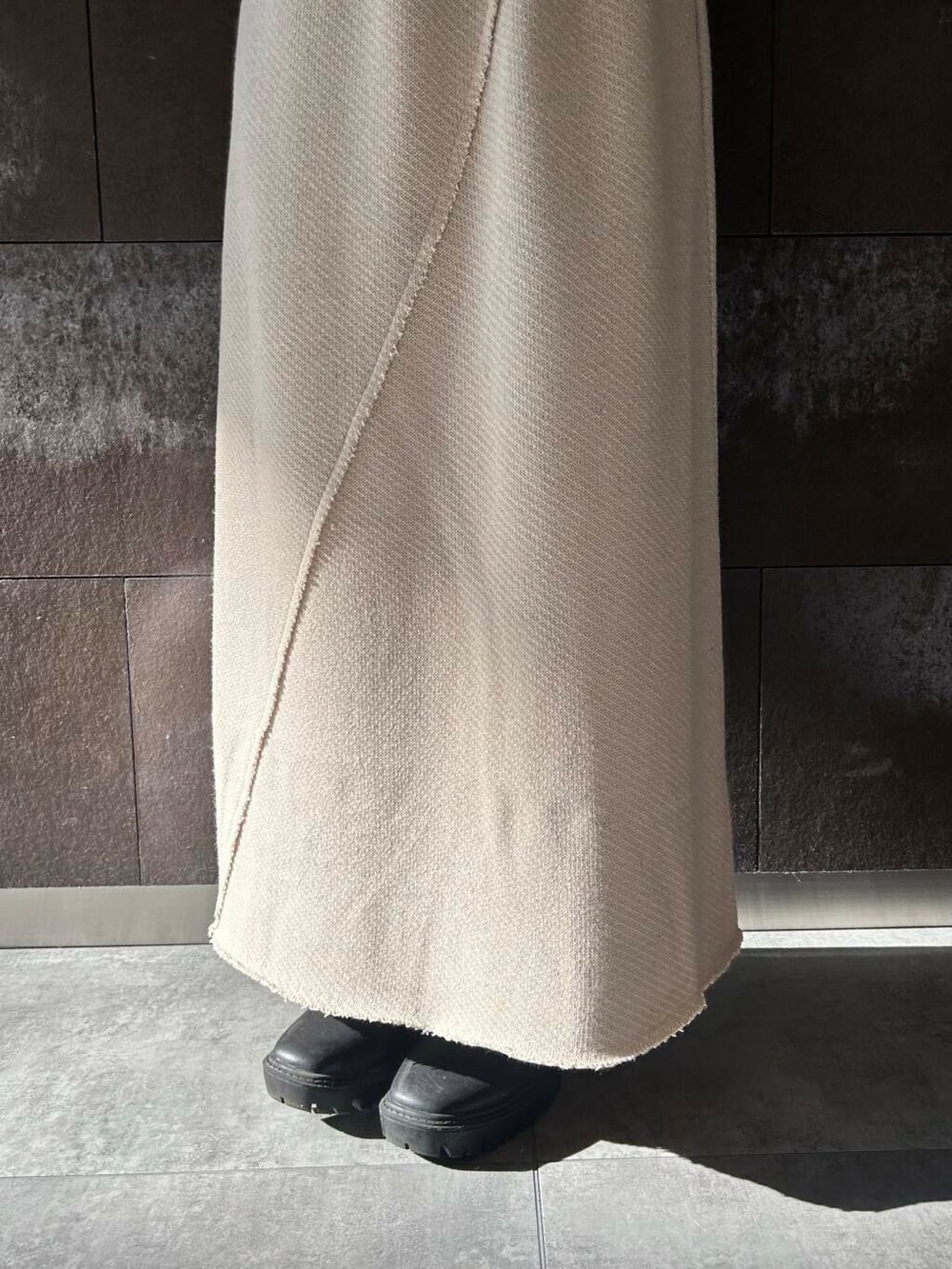 ベージュ系のTシャツ/カットソー、ベージュ系のスカート、ブラック系のショルダーバッグを着用したレディースの秋コーディネートの7枚目の写真