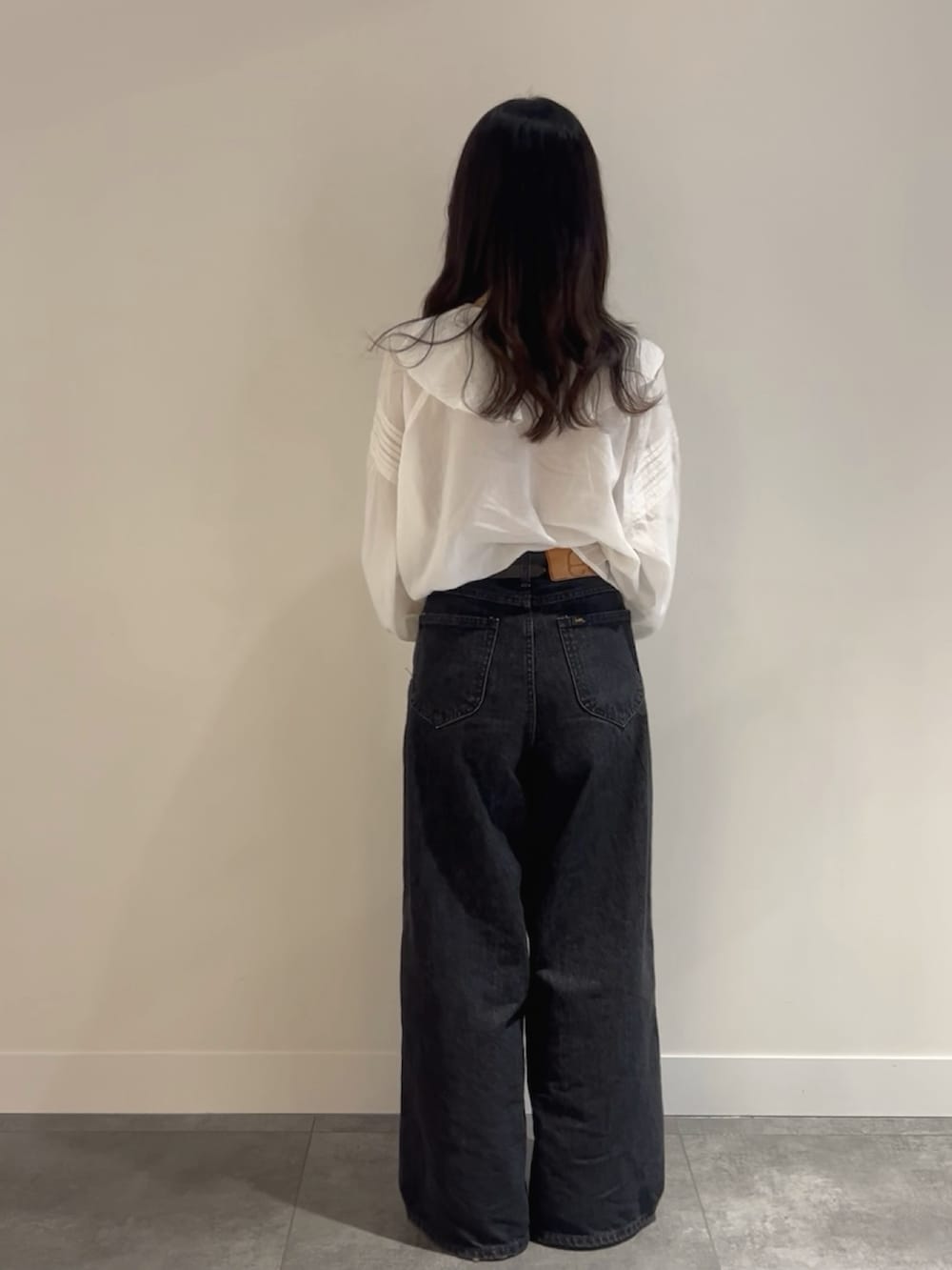 ブラック系のデニムパンツ、ブラック系のショルダーバッグ、ホワイト系のシャツ/ブラウスを着用したレディースの春コーディネートの3枚目の写真