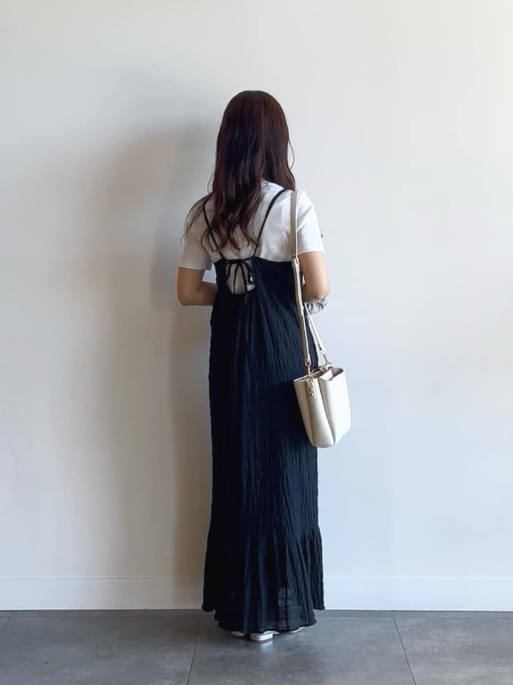 ホワイト系のTシャツ/カットソー、ブラック系のワンピース、ホワイト系のショルダーバッグを着用したレディースの夏コーディネートの3枚目の写真