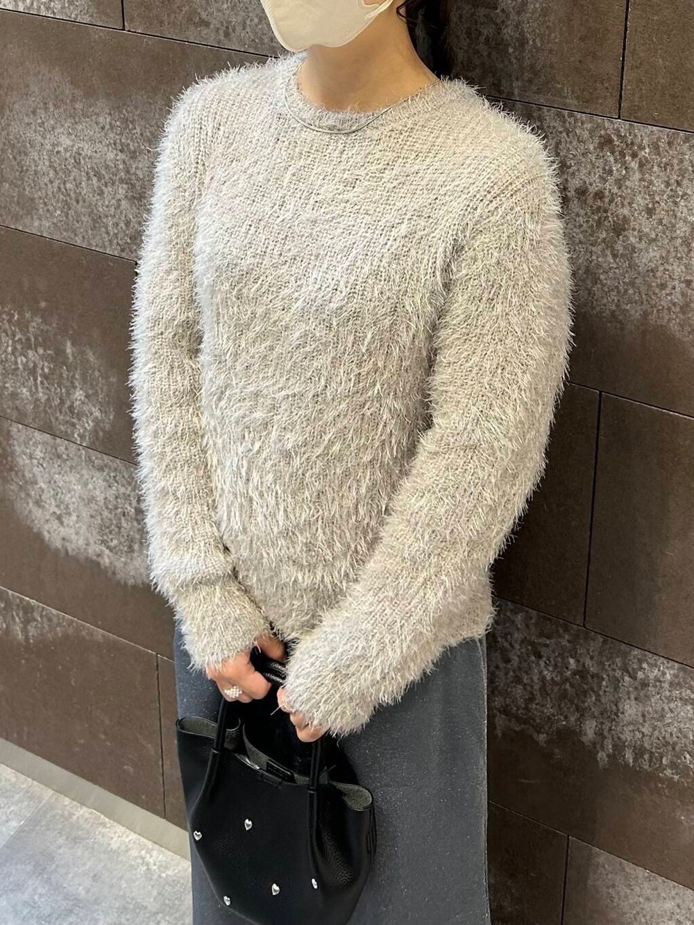 ブラック系のブーツ、グレー系のスカート、ブラック系のショルダーバッグを着用したレディースの冬コーディネートの3枚目の写真