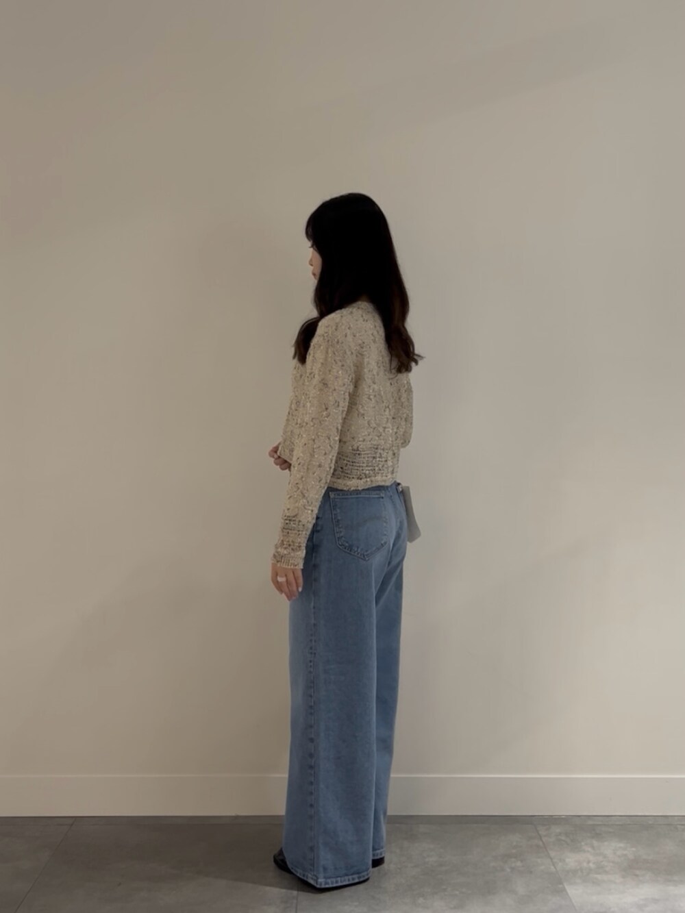 ブラック系のローファー、ブルー系のデニムパンツ、ブラック系のショルダーバッグを着用したレディースの春コーディネートの3枚目の写真