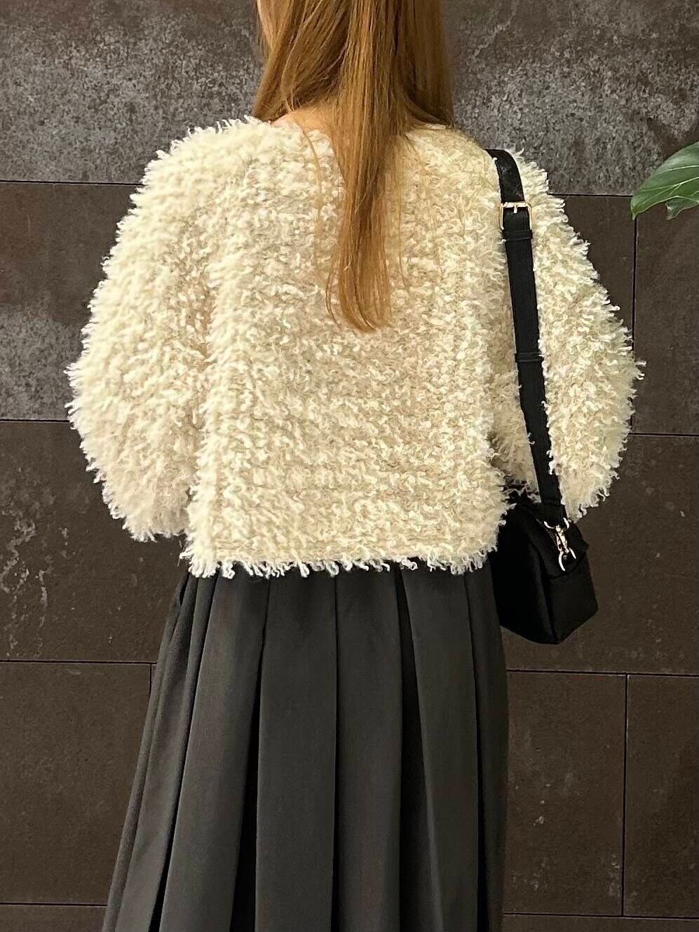 グレー系のスカート、ブラック系のその他シューズ、ホワイト系のニット/セーターを着用したレディースの秋コーディネートの5枚目の写真