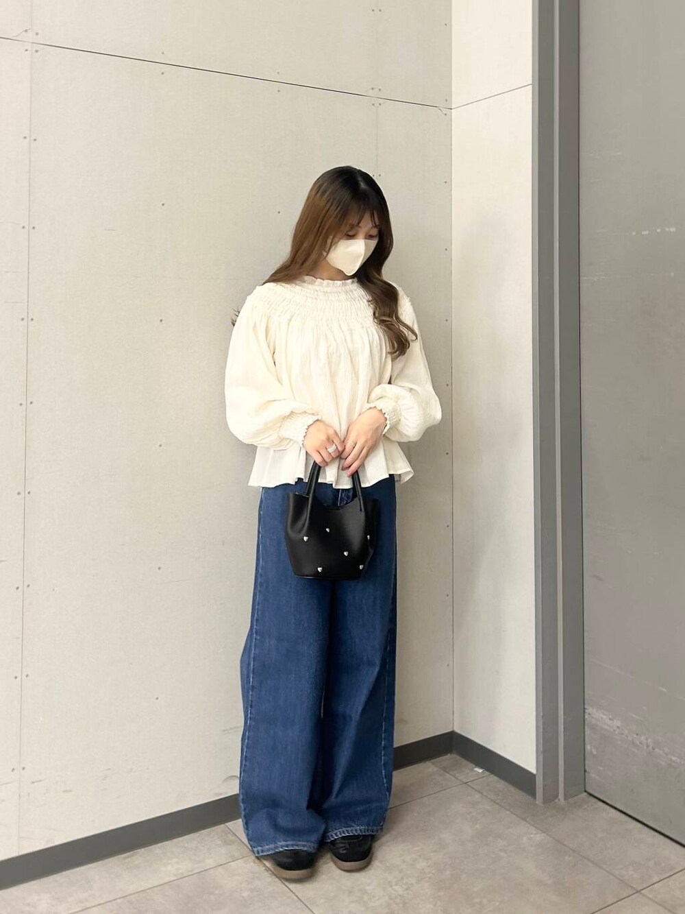 ブラック系のショルダーバッグ、ホワイト系のシャツ/ブラウスを着用したレディースの春コーディネートの2枚目の写真