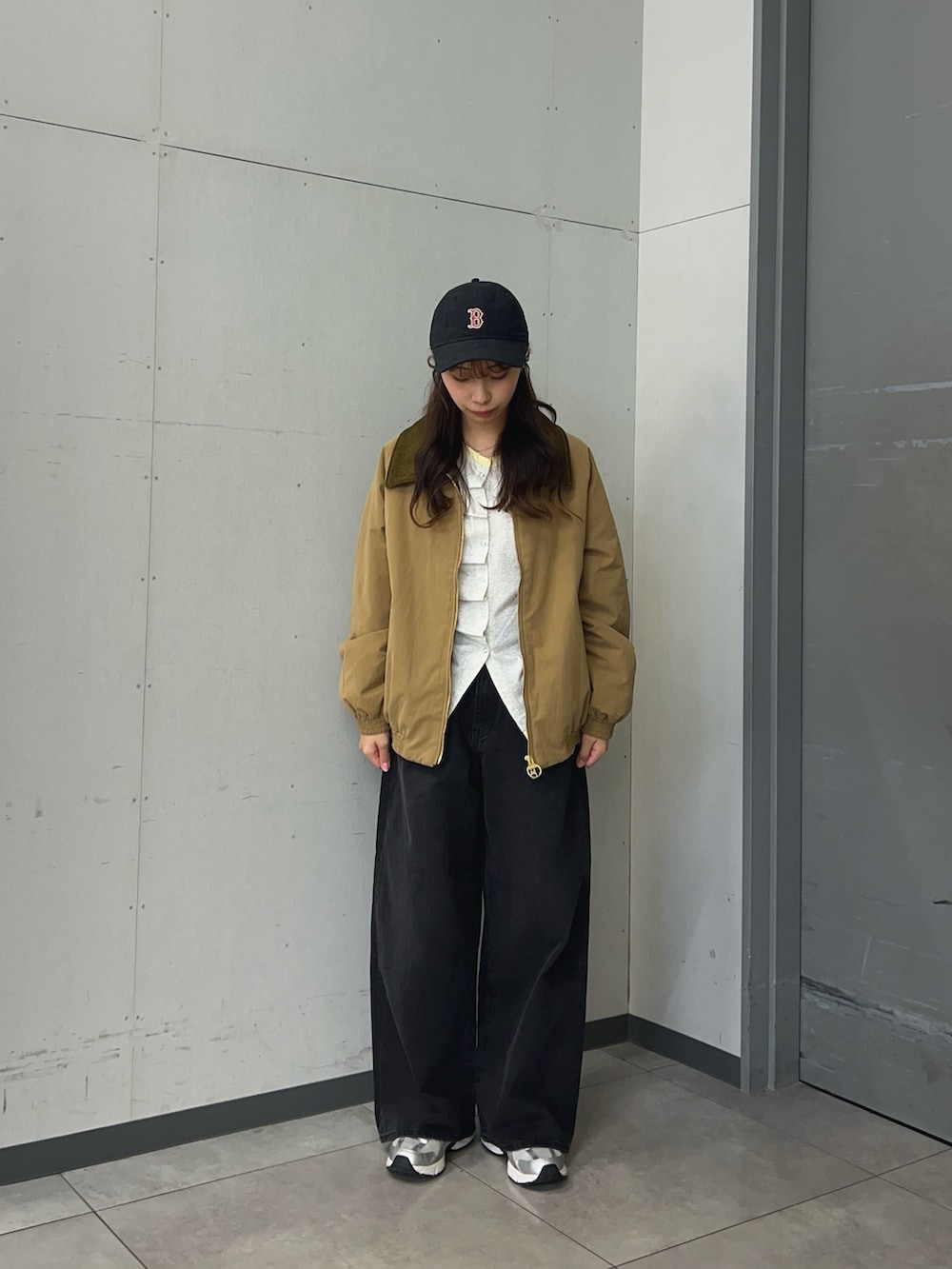 ベージュ系のTシャツ/カットソー、ベージュ系のダウンジャケット/コート、ブラック系のデニムパンツを着用したレディースの秋コーディネートの2枚目の写真