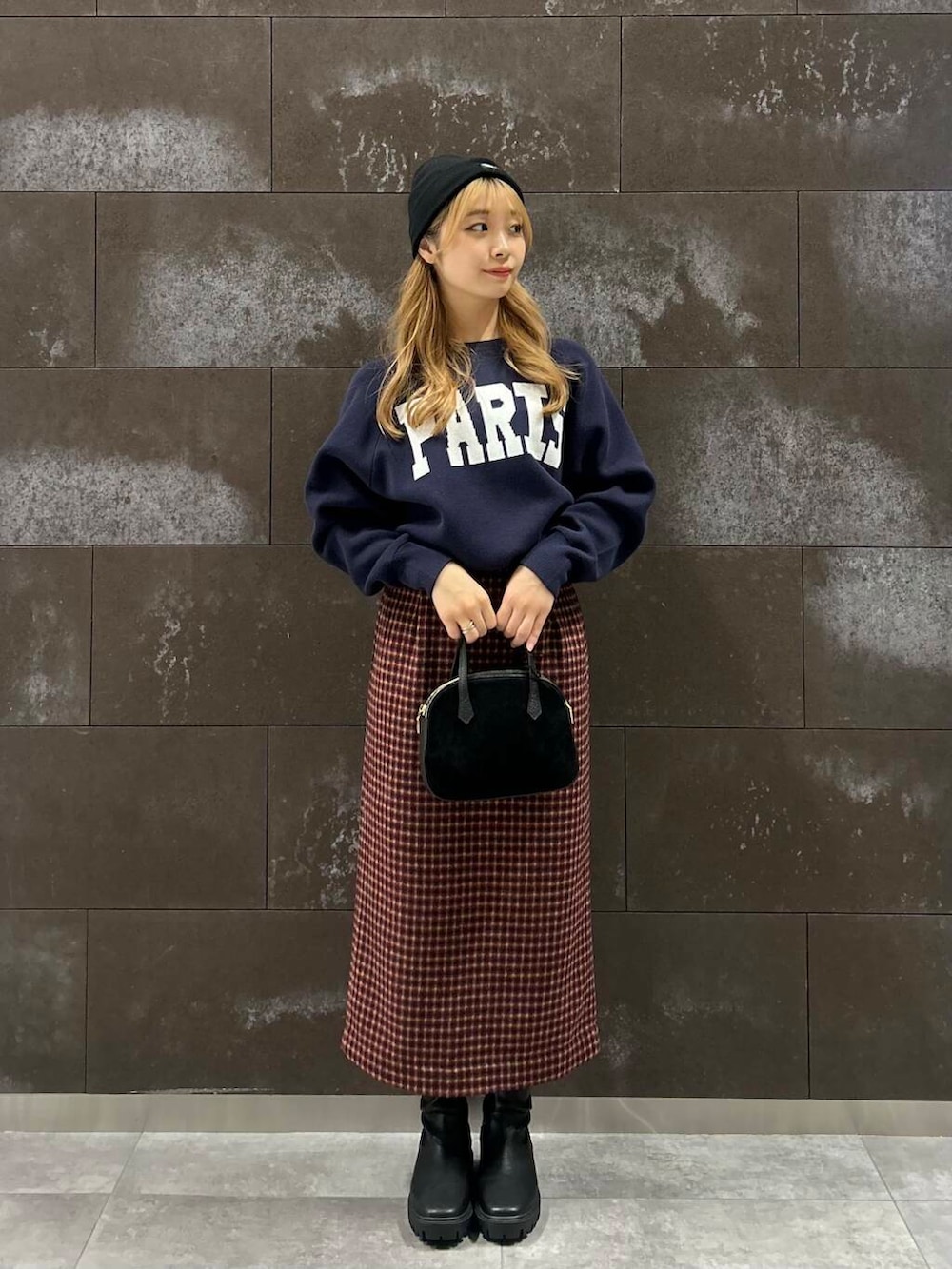 ブラック系のショルダーバッグ、ブラック系のブーツ、ブルー系のニット/セーターを着用したレディースの秋コーディネートの2枚目の写真