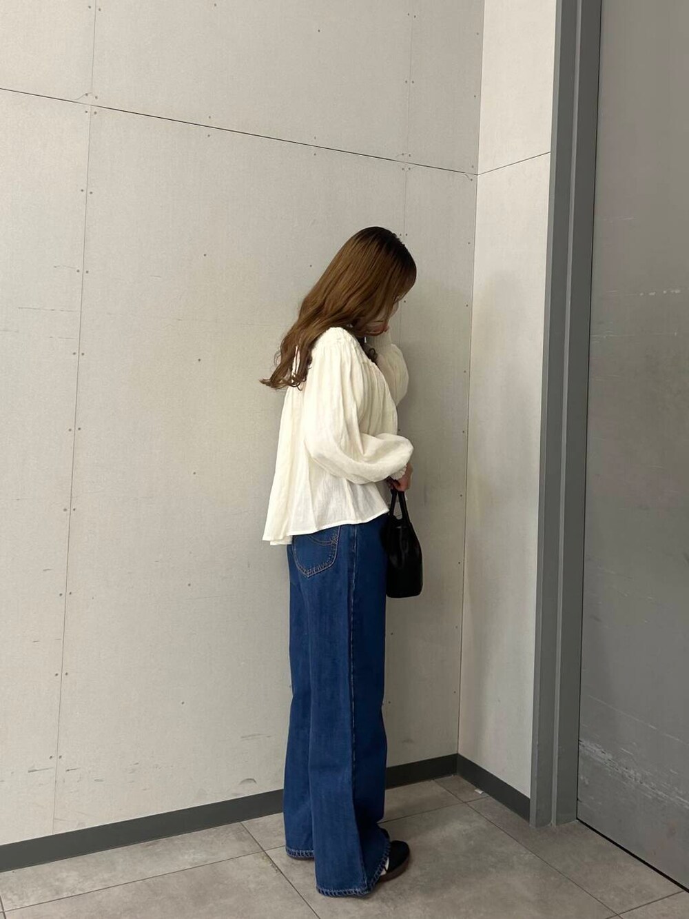 ブラック系のショルダーバッグ、ホワイト系のシャツ/ブラウスを着用したレディースの春コーディネートの3枚目の写真