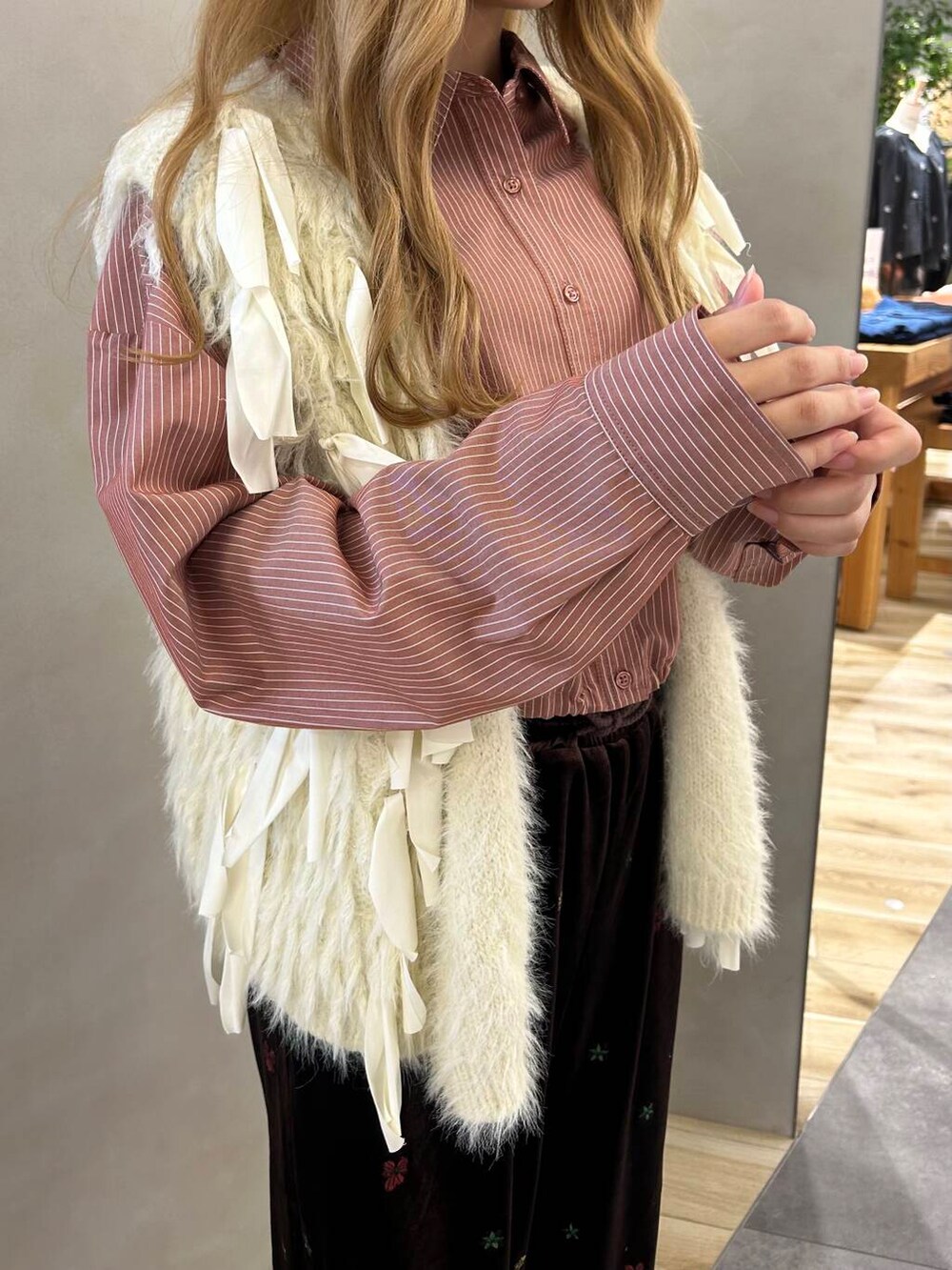 ホワイト系のスニーカー、ホワイト系のベスト、レッド系のシャツ/ブラウスを着用したレディースの秋コーディネートの2枚目の写真