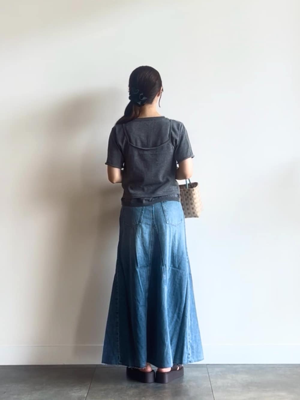 グレー系のカーディガン/ボレロ、ブルー系のスカート、ベージュ系のショルダーバッグを着用したレディースの夏コーディネートの4枚目の写真