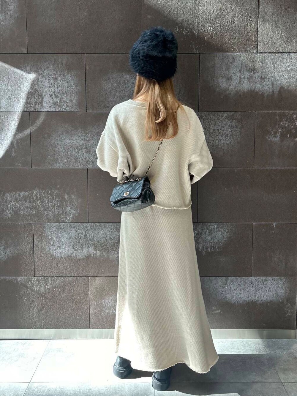 ベージュ系のTシャツ/カットソー、ベージュ系のスカート、ブラック系のショルダーバッグを着用したレディースの秋コーディネートの3枚目の写真