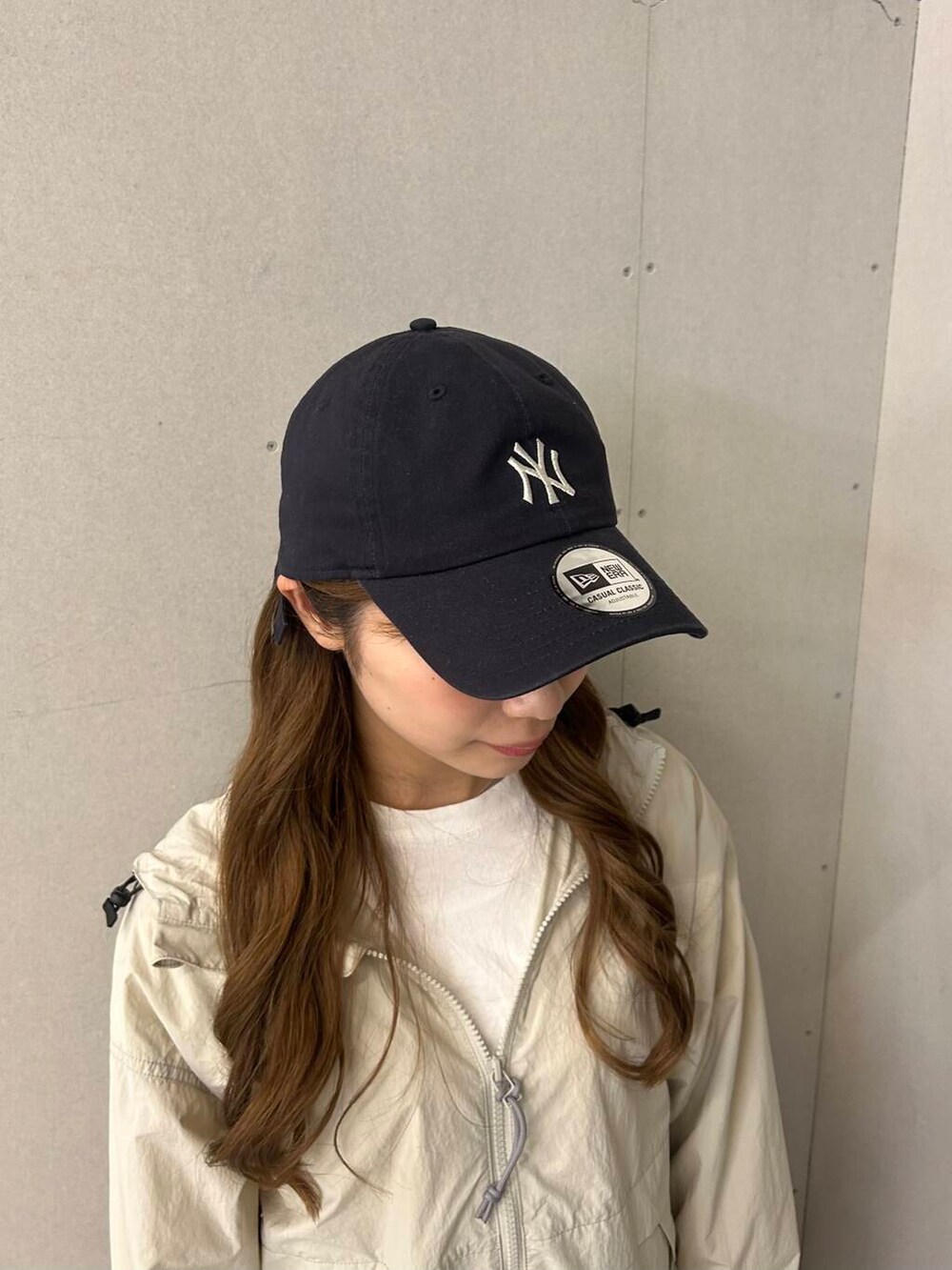 ホワイト系のTシャツ/カットソー、ブラック系のスカート、ホワイト系のナイロンジャケットを着用したレディースの春コーディネートの5枚目の写真