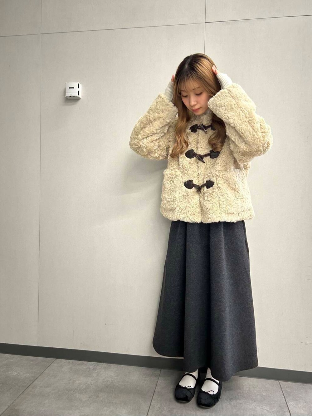 ブラック系のバレエシューズ、ホワイト系のその他アウター、ホワイト系のニット/セーターを着用したレディースの冬コーディネートの2枚目の写真