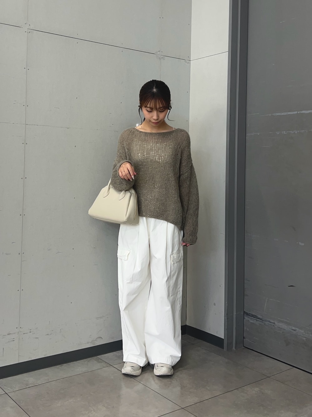 ホワイト系のその他パンツ、ホワイト系のハンドバッグを着用したレディースの秋コーディネートの2枚目の写真