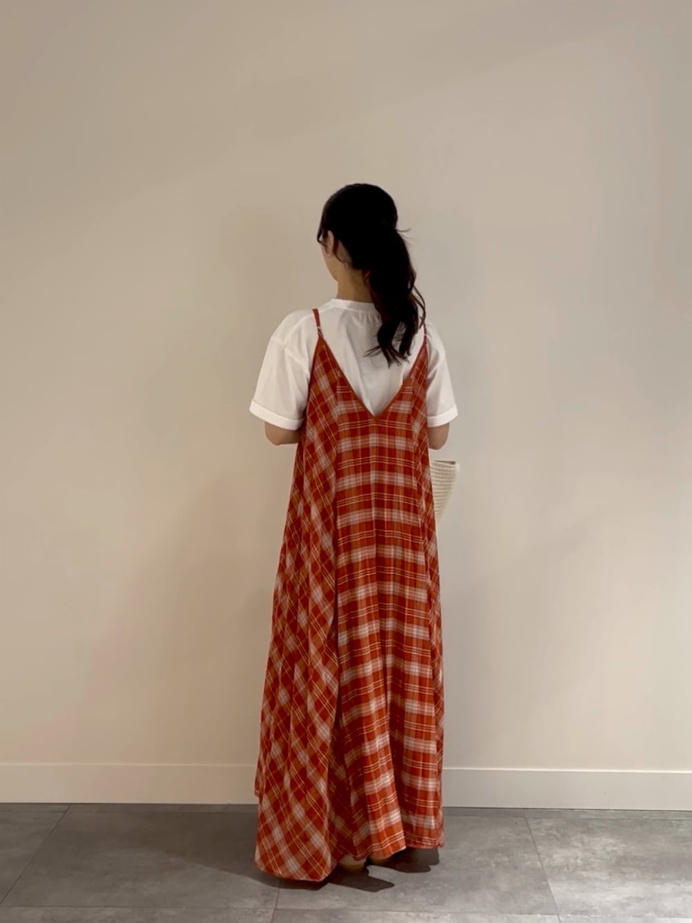 レッド系のワンピース、ホワイト系のトートバッグ、ベージュ系のサンダルを着用したレディースの春コーディネートの3枚目の写真