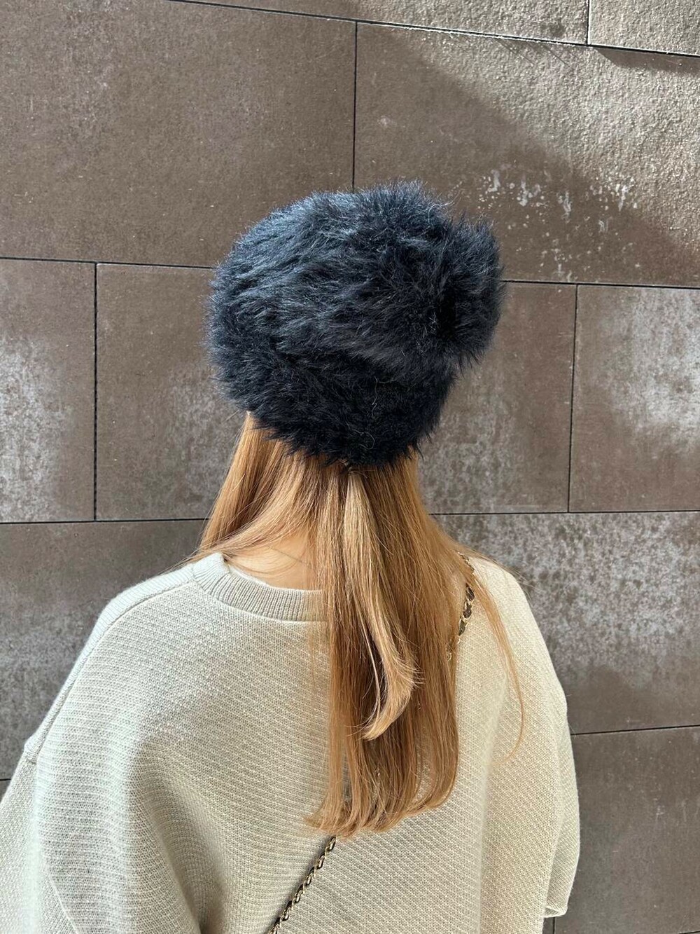 ベージュ系のTシャツ/カットソー、ベージュ系のスカート、ブラック系のショルダーバッグを着用したレディースの秋コーディネートの4枚目の写真