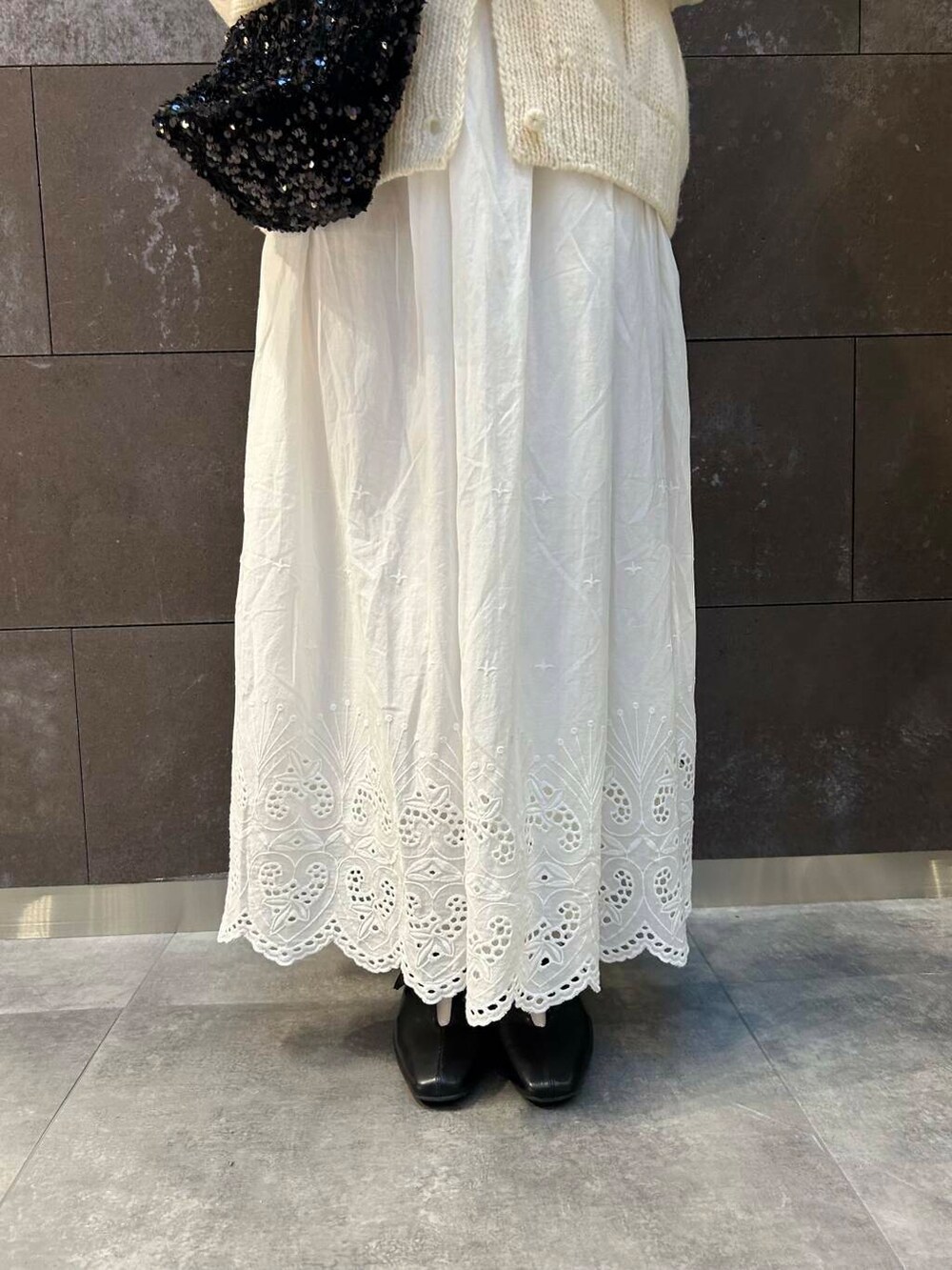 ホワイト系のニット/セーター、ブラック系のその他シューズ、ホワイト系のスカートを着用したレディースの秋コーディネートの5枚目の写真