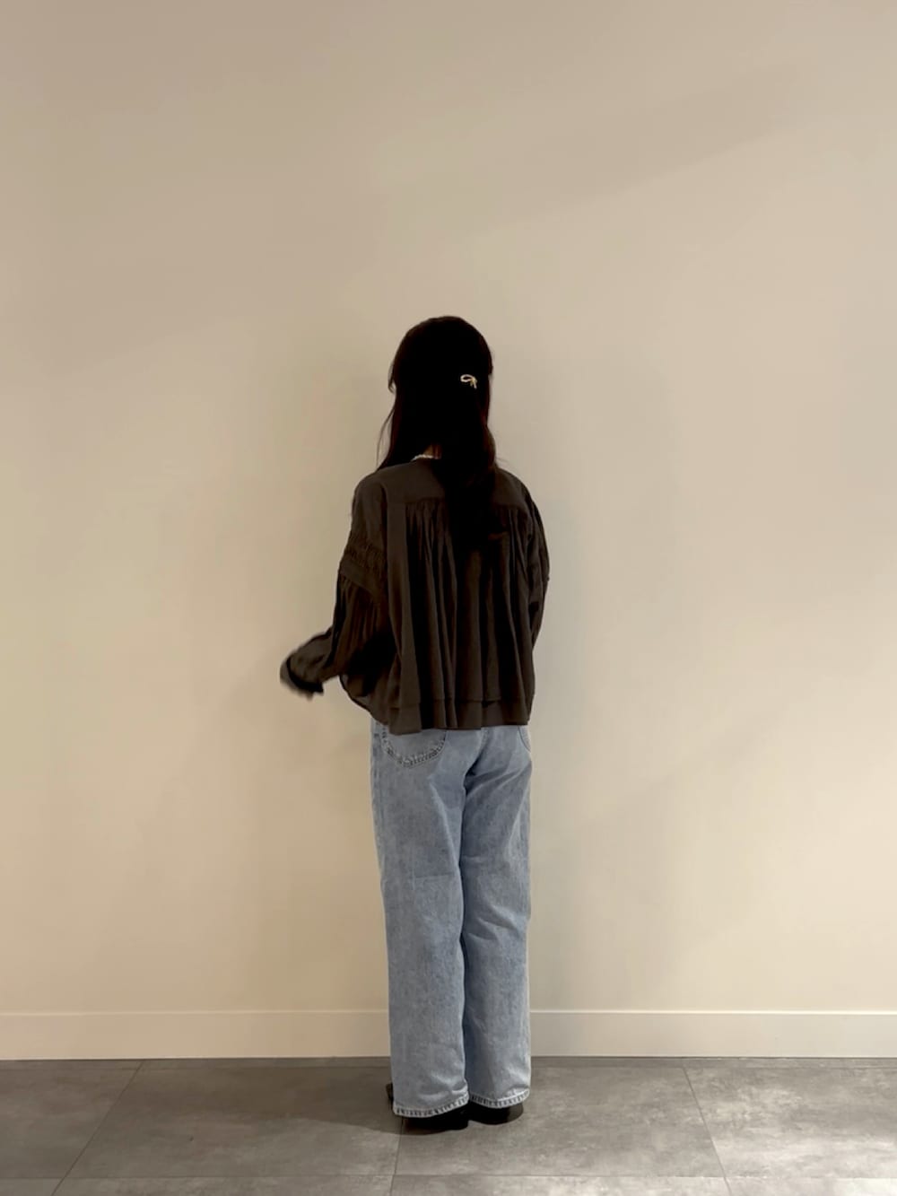 ホワイト系のボストンバッグ、ブルー系のデニムパンツ、ホワイト系のタンクトップを着用したレディースの春コーディネートの3枚目の写真