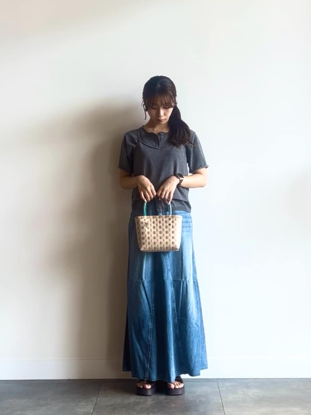 グレー系のカーディガン/ボレロ、ブルー系のスカート、ベージュ系のショルダーバッグを着用したレディースの夏コーディネートの2枚目の写真