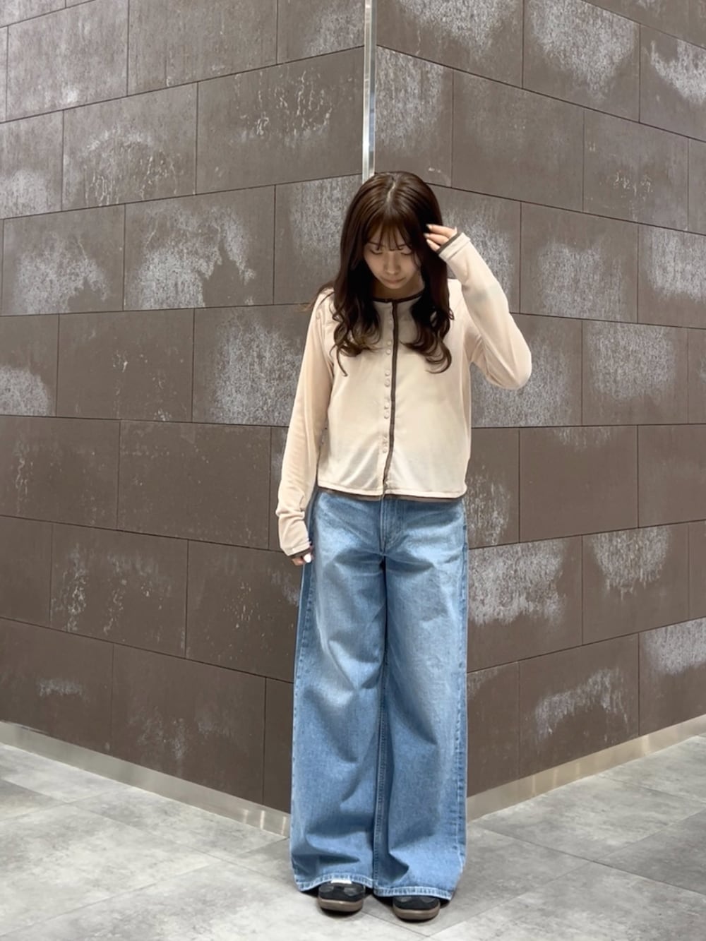 ホワイト系のタンクトップ、ピンク系のカーディガン/ボレロ、ブルー系のデニムパンツを着用したレディースの春コーディネートの2枚目の写真