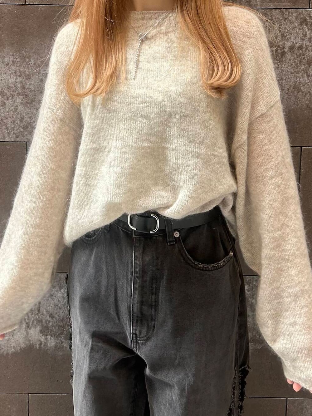 ブラック系のスニーカー、レッド系のボストンバッグ、ブラック系のデニムパンツを着用したレディースの秋コーディネートの2枚目の写真