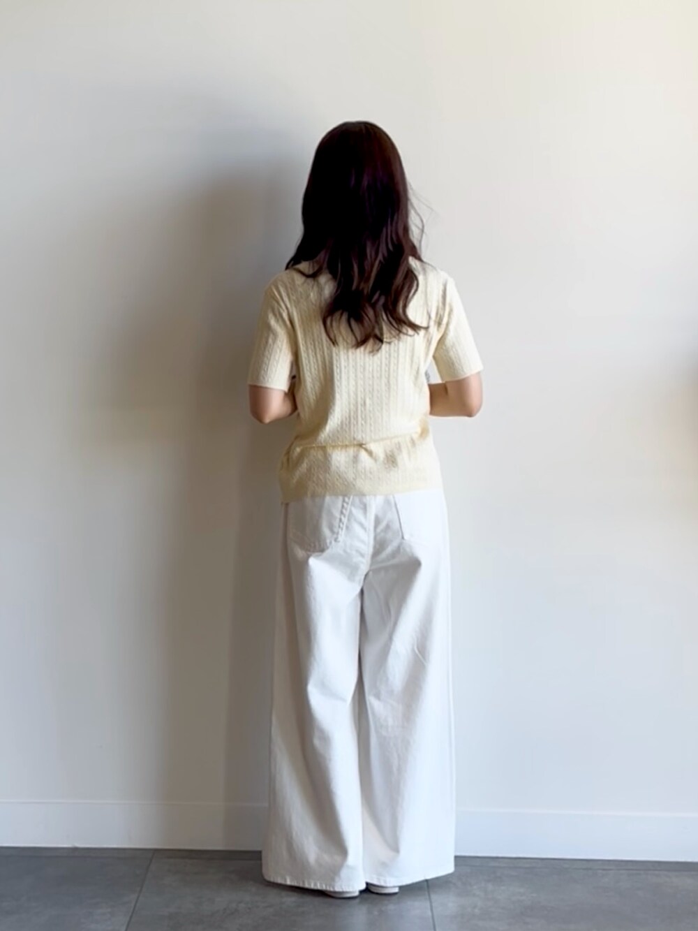 ホワイト系のニット/セーター、ホワイト系のデニムパンツを着用したレディースの夏コーディネートの4枚目の写真