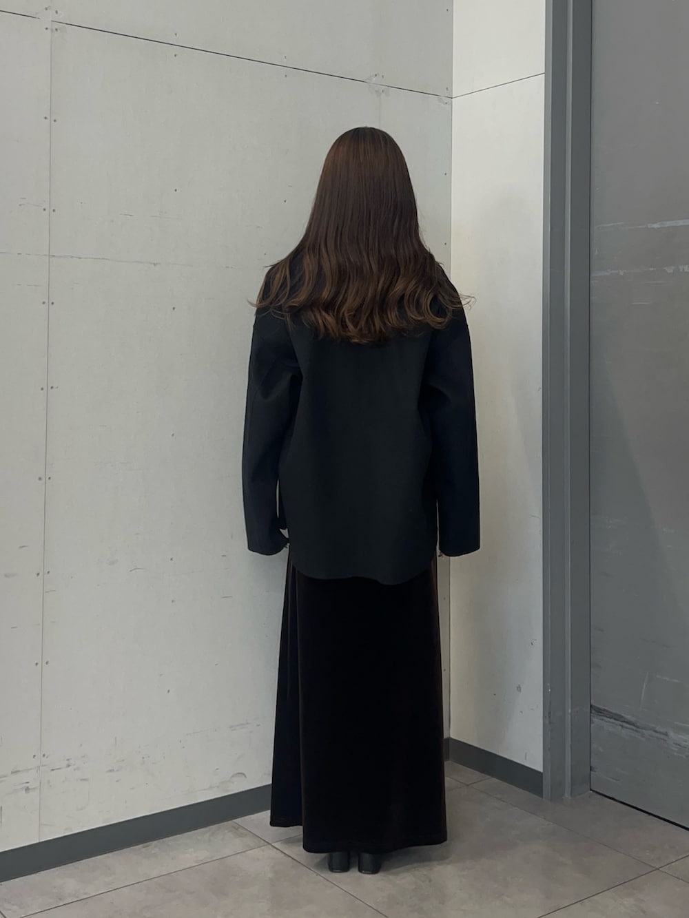 ベージュ系のカーディガン/ボレロ、ブラック系のノーカラージャケット、ブラウン系のスカートを着用したレディースの秋コーディネートの6枚目の写真