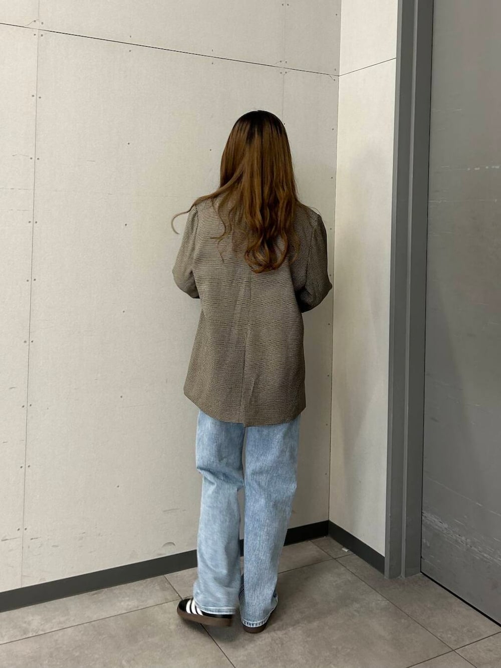 ブルー系のデニムパンツ、ブラック系のその他アウター、ホワイト系のTシャツ/カットソーを着用したレディースの春コーディネートの3枚目の写真