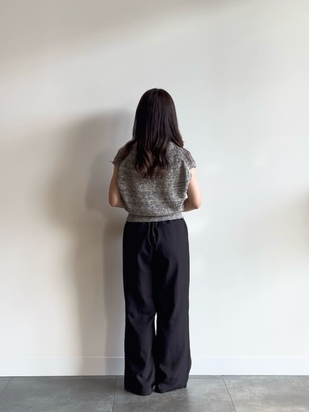 ホワイト系のタンクトップ、ブラック系のニット/セーター、ブラック系のその他パンツを着用したレディースの夏コーディネートの4枚目の写真