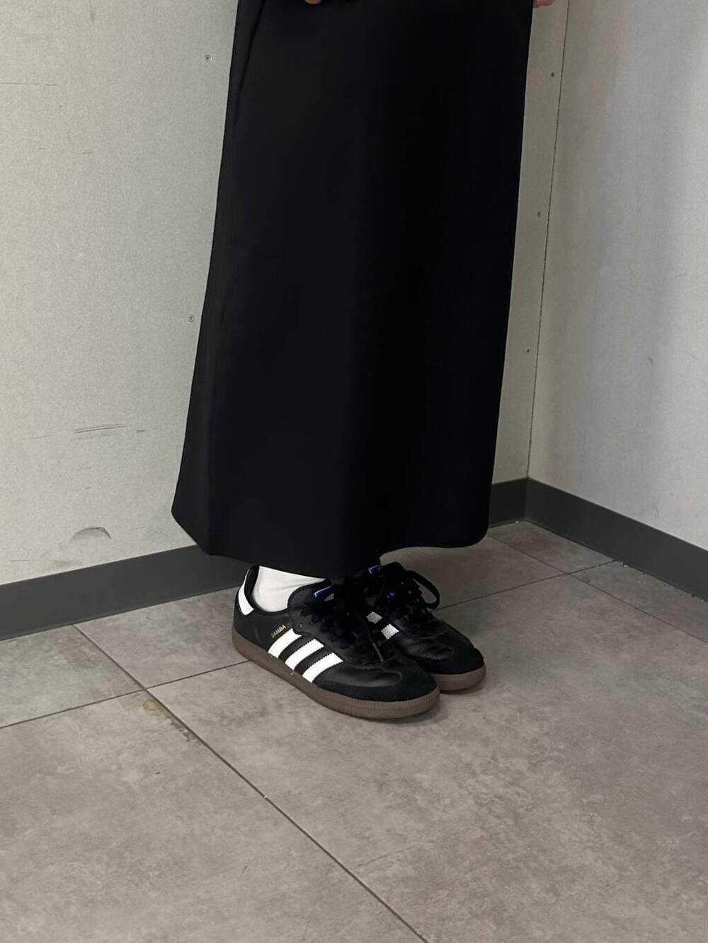 ホワイト系のTシャツ/カットソー、ブラック系のスカート、ホワイト系のナイロンジャケットを着用したレディースの春コーディネートの6枚目の写真