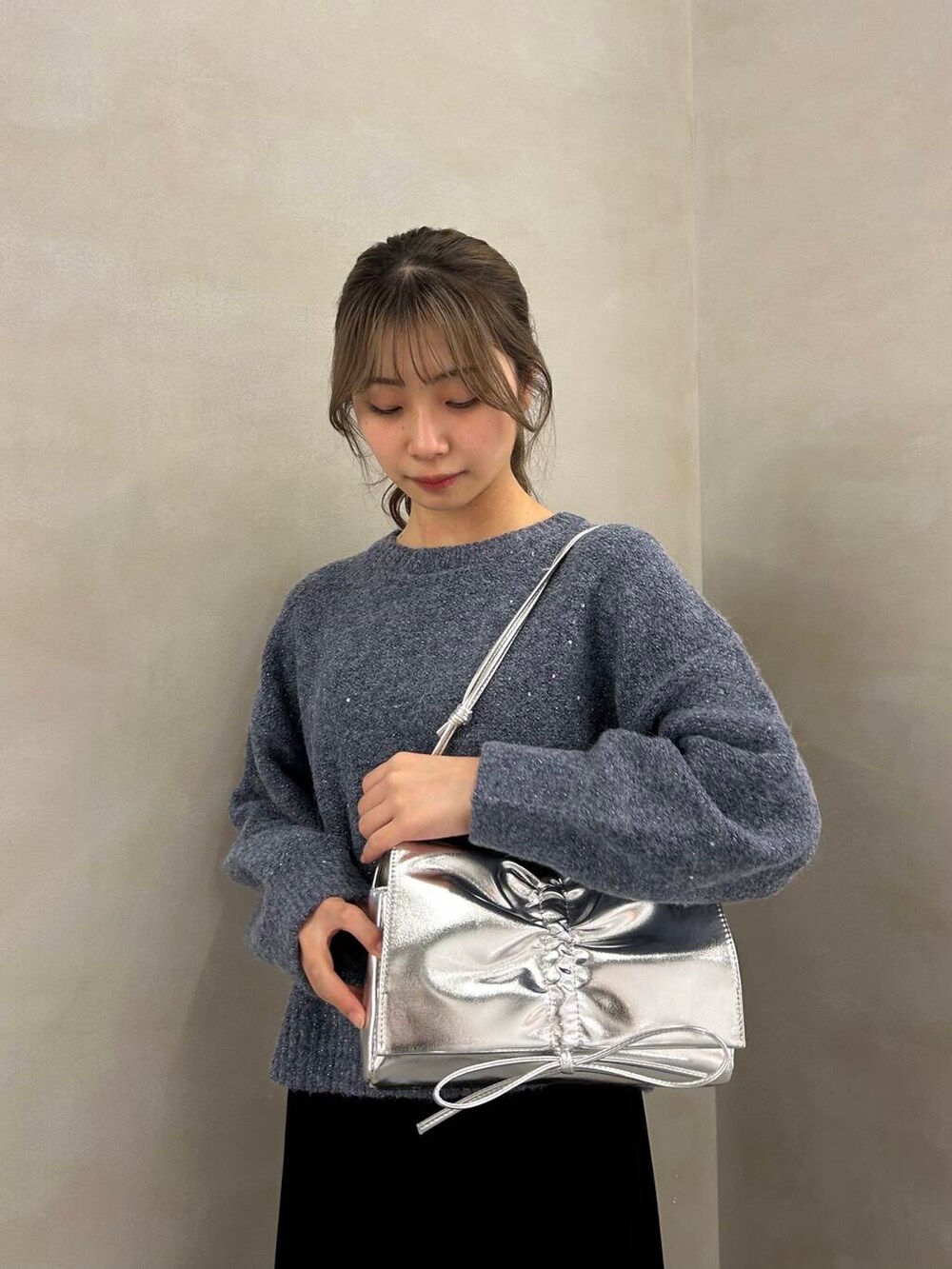 シルバー系のブーツ、ブラック系のスカート、シルバー系のショルダーバッグを着用したレディースの冬コーディネートの4枚目の写真