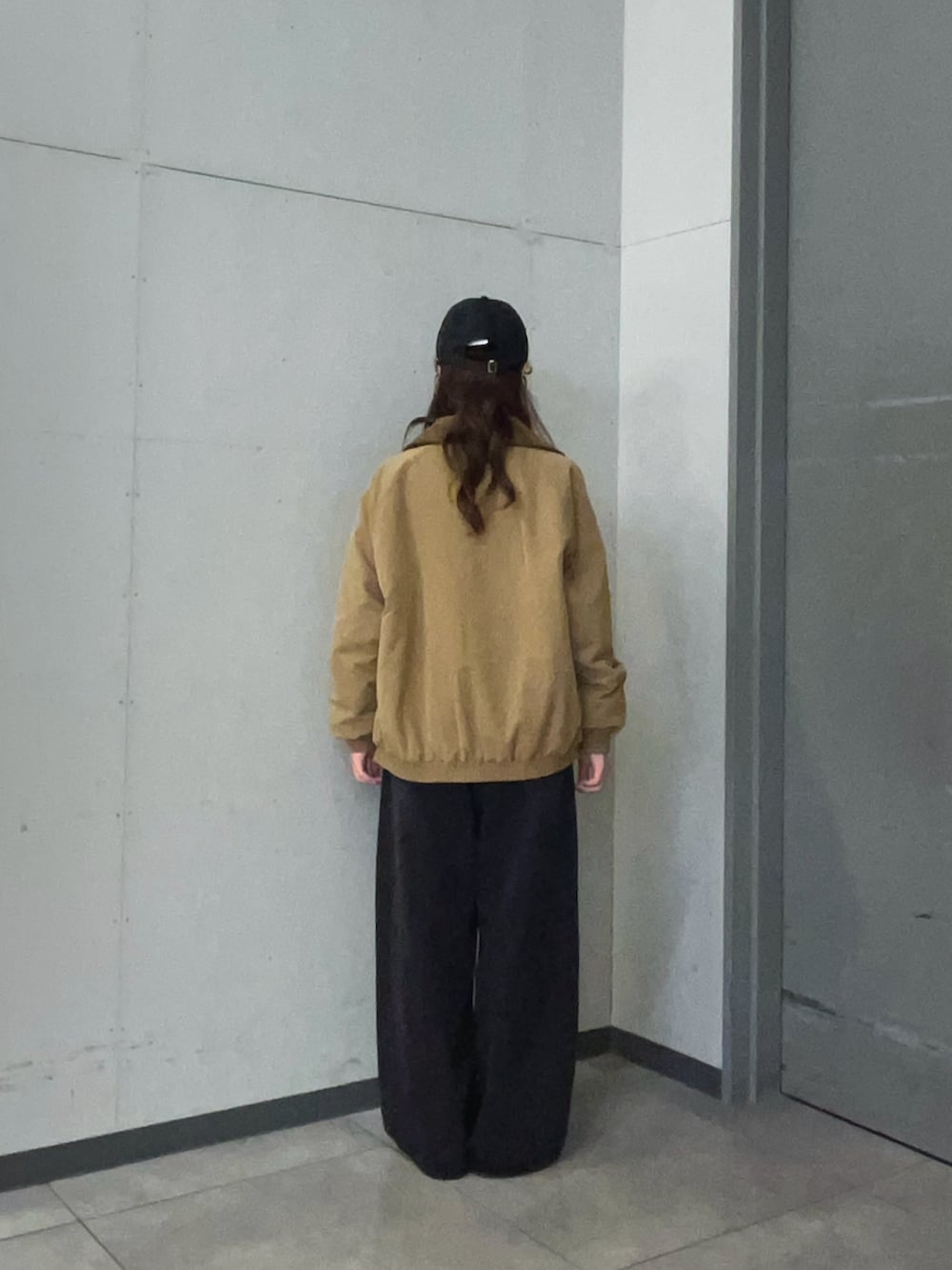 ベージュ系のTシャツ/カットソー、ベージュ系のダウンジャケット/コート、ブラック系のデニムパンツを着用したレディースの秋コーディネートの4枚目の写真