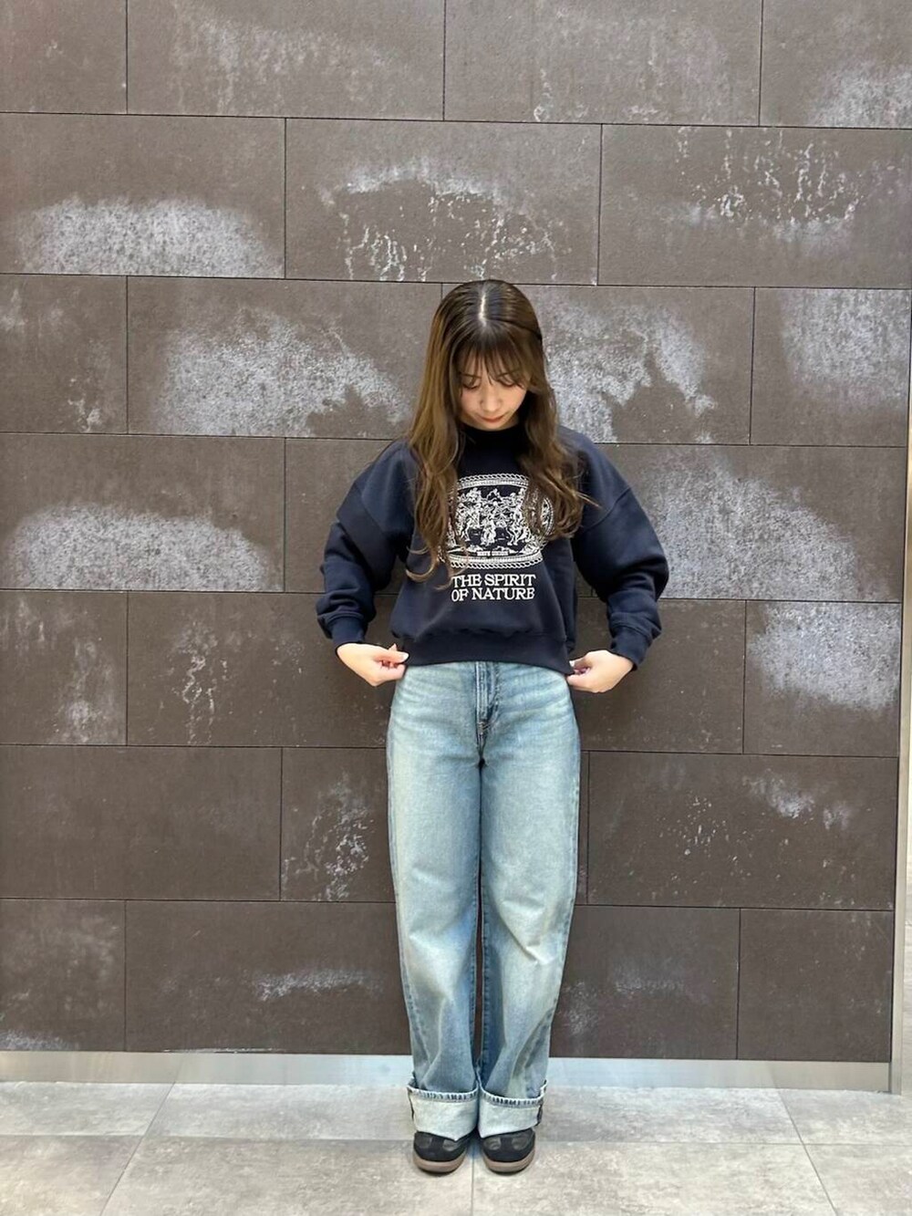 ブルー系のスウェット、ブルー系のデニムパンツを着用したレディースの冬コーディネートの2枚目の写真