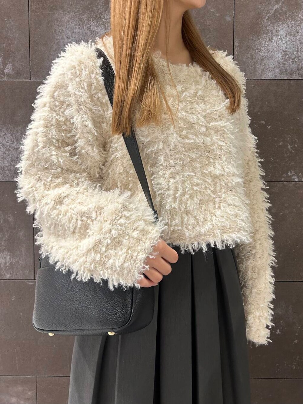 グレー系のスカート、ブラック系のその他シューズ、ホワイト系のニット/セーターを着用したレディースの秋コーディネートの3枚目の写真