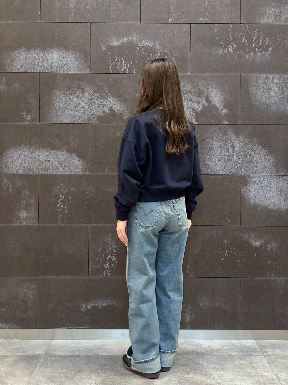 ブルー系のスウェット、ブルー系のデニムパンツを着用したレディースの冬コーディネートの3枚目の写真