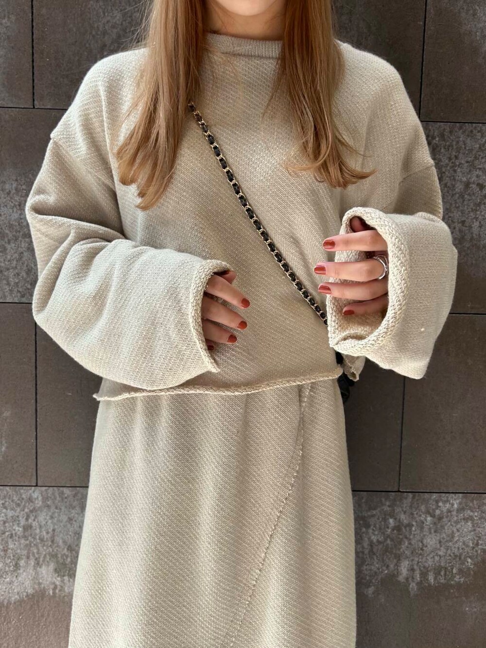 ベージュ系のTシャツ/カットソー、ベージュ系のスカート、ブラック系のショルダーバッグを着用したレディースの秋コーディネートの5枚目の写真