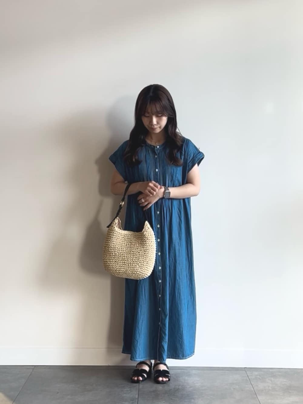 ブルー系のワンピース、ベージュ系のトートバッグ、ブラック系のサンダルを着用したレディースの夏コーディネートの2枚目の写真