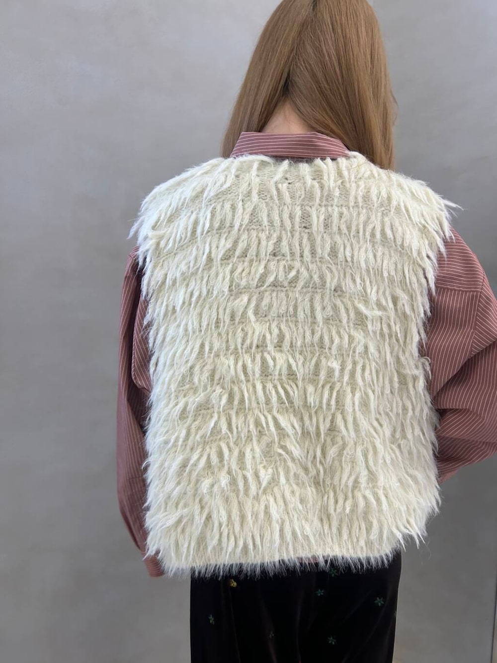 ホワイト系のスニーカー、ホワイト系のベスト、レッド系のシャツ/ブラウスを着用したレディースの秋コーディネートの3枚目の写真