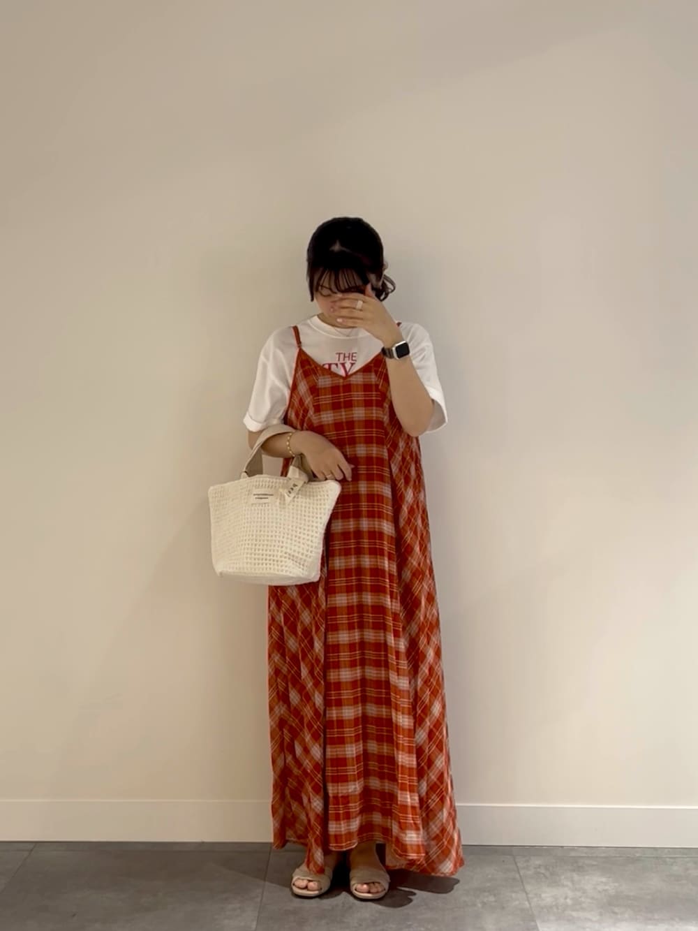 レッド系のワンピース、ホワイト系のトートバッグ、ベージュ系のサンダルを着用したレディースの春コーディネートの2枚目の写真