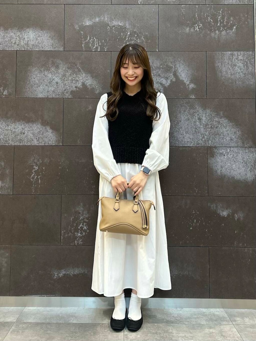 ブラック系のバレエシューズ、ブラウン系のボストンバッグ、ブラック系のワンピースを着用したレディースの冬コーディネートの2枚目の写真