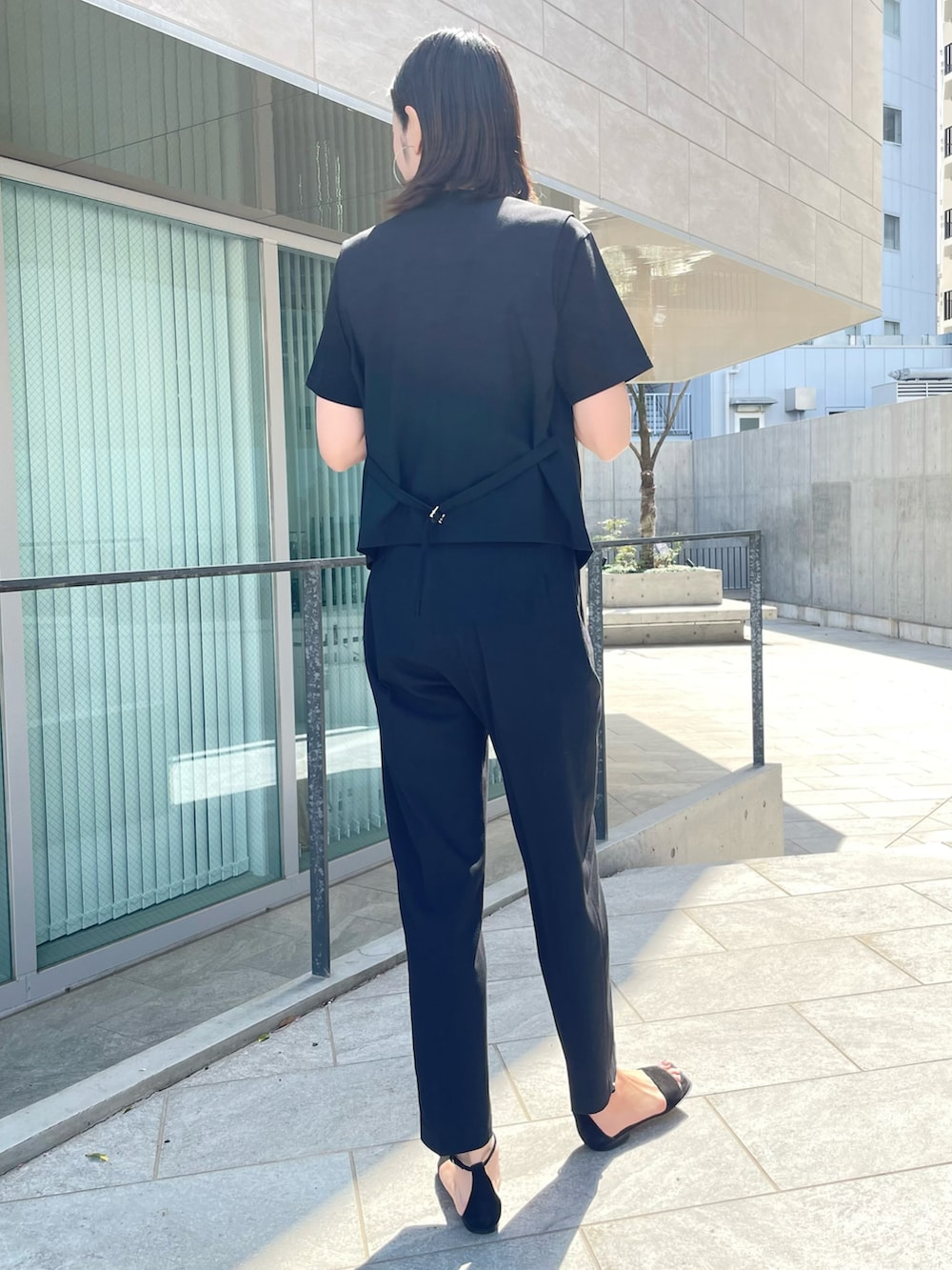 ブラック系のベスト、ブラック系のパンツ、ブラック系のTシャツ/カットソーを着用したレディースの春コーディネートの2枚目の写真
