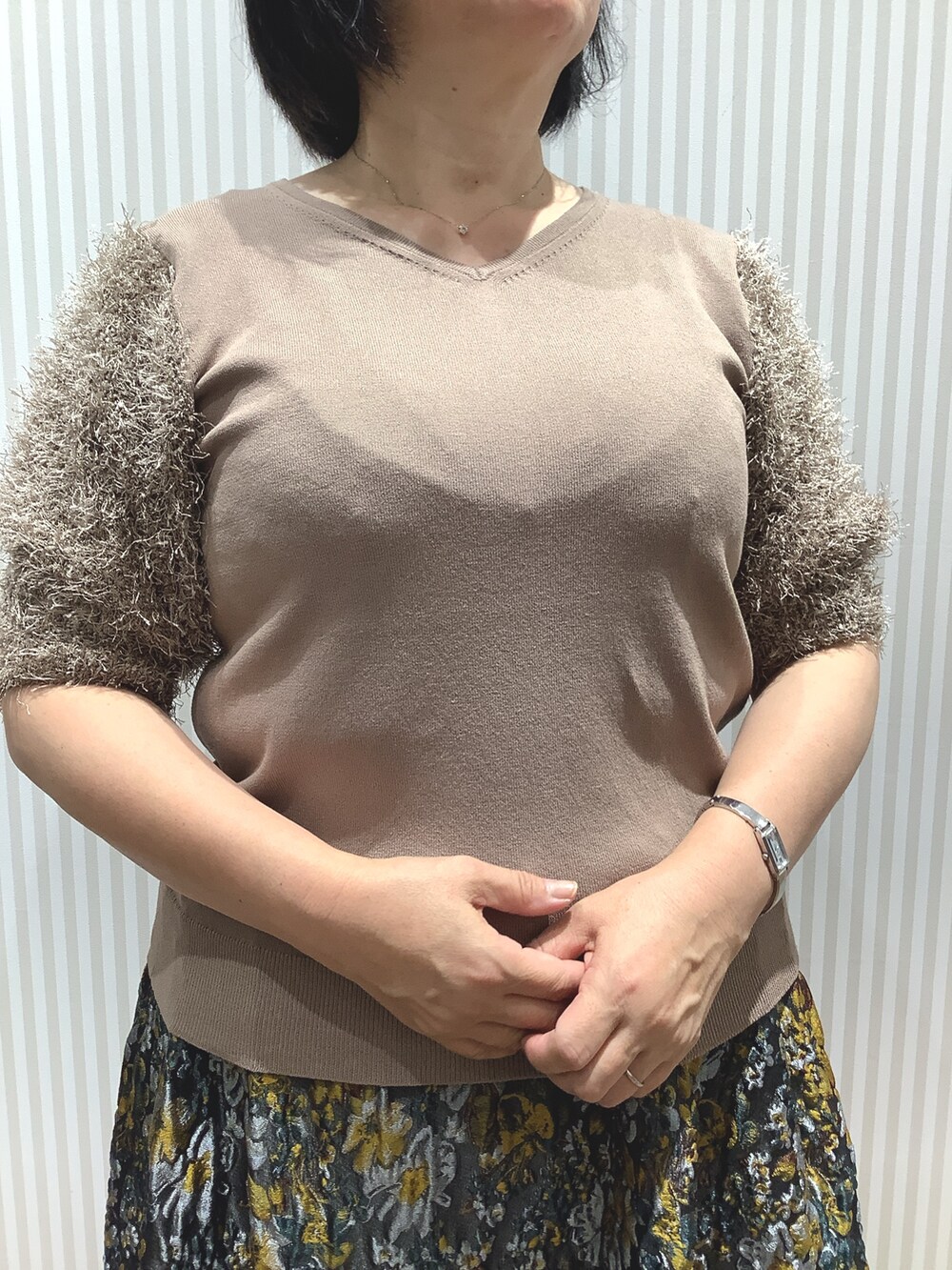 ブラウン系のニット/セーターを着用したレディースの夏コーディネートの2枚目の写真