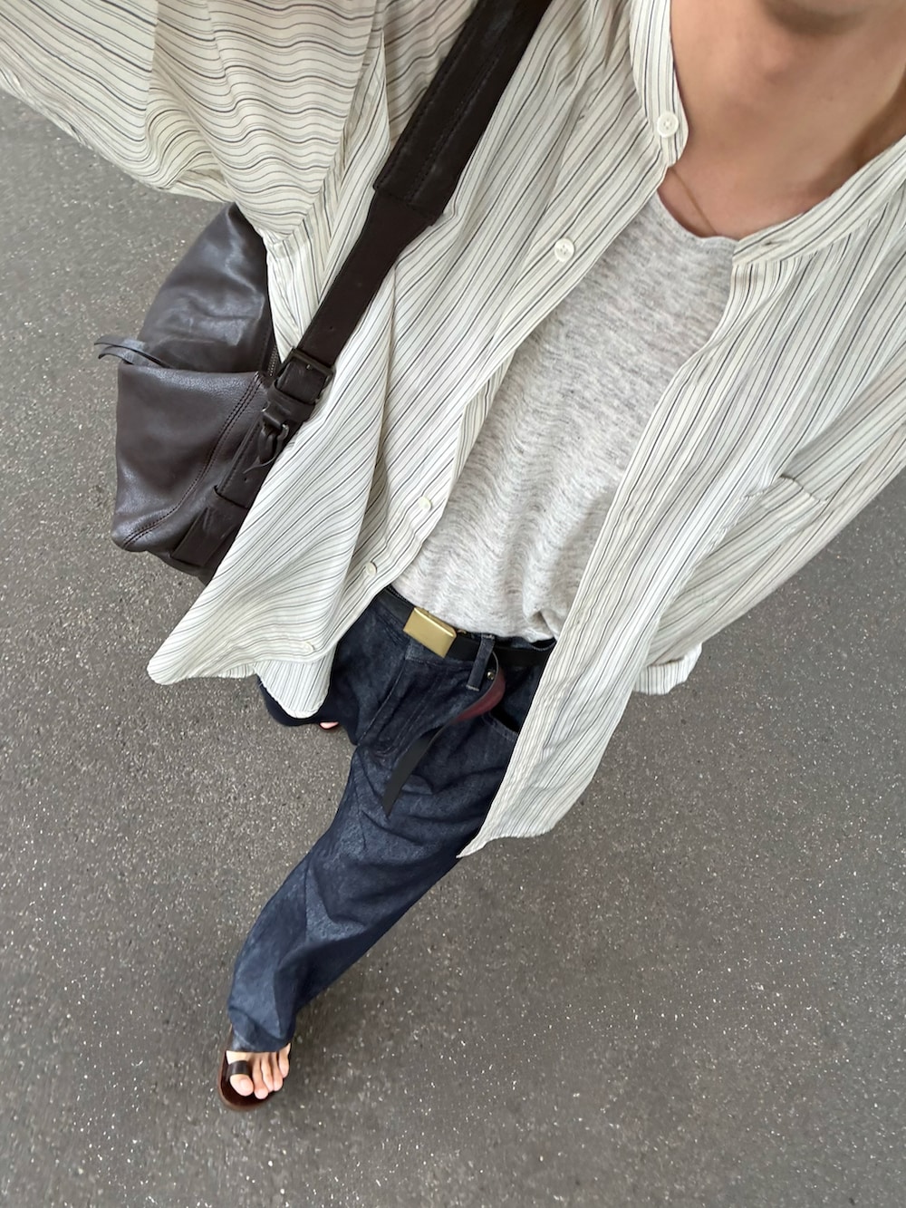 グレー系のタンクトップ、ホワイト系のシャツ/ブラウス、ブルー系のデニムパンツを着用したメンズの夏コーディネートの2枚目の写真