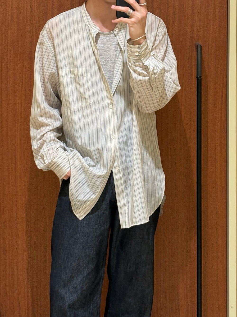 グレー系のタンクトップ、ホワイト系のシャツ/ブラウス、ブルー系のデニムパンツを着用したメンズの夏コーディネートの3枚目の写真