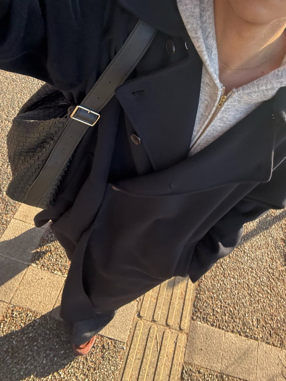 ブルー系のトレンチコート、グレー系のパーカー、ブラック系のスラックスを着用したメンズの秋コーディネートの3枚目の写真