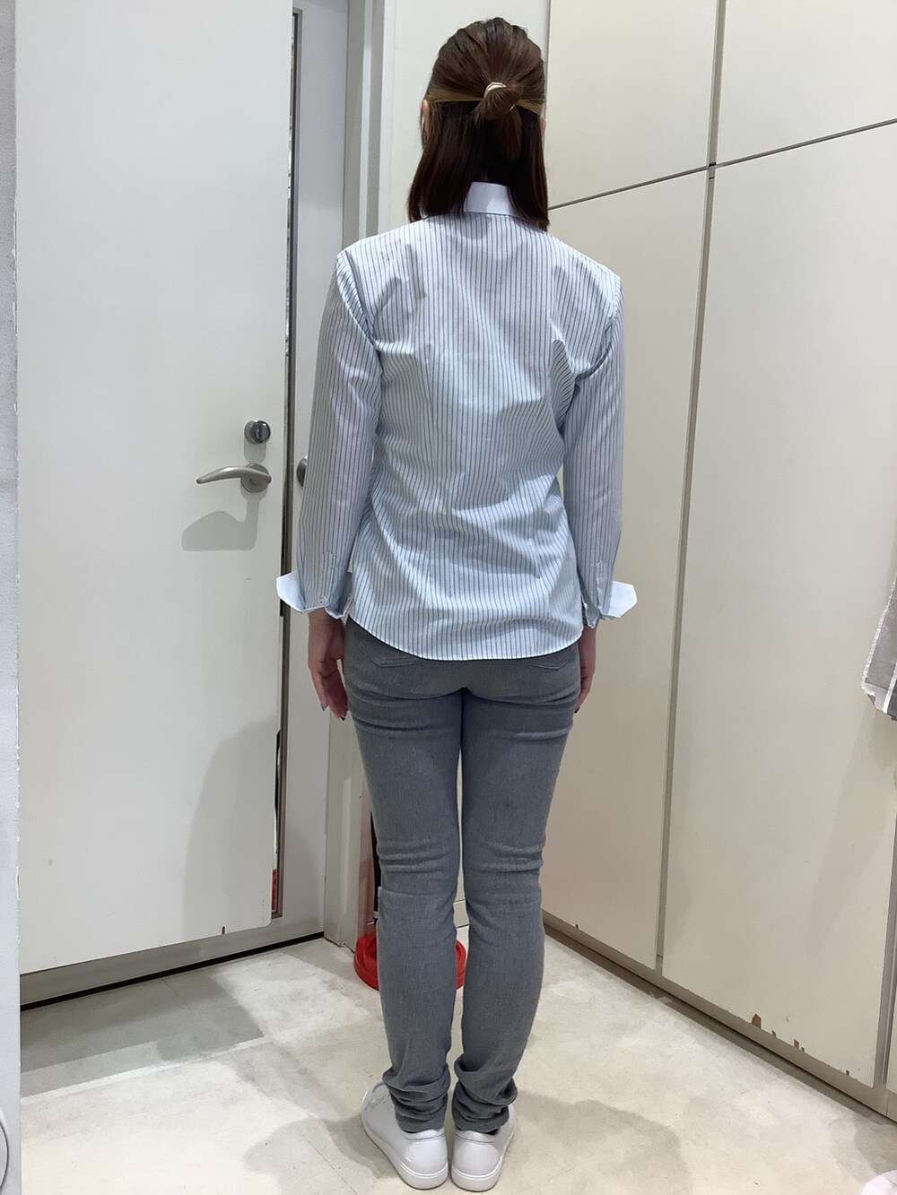 グリーン系のビジネスシャツを着用したレディースの春コーディネートの3枚目の写真