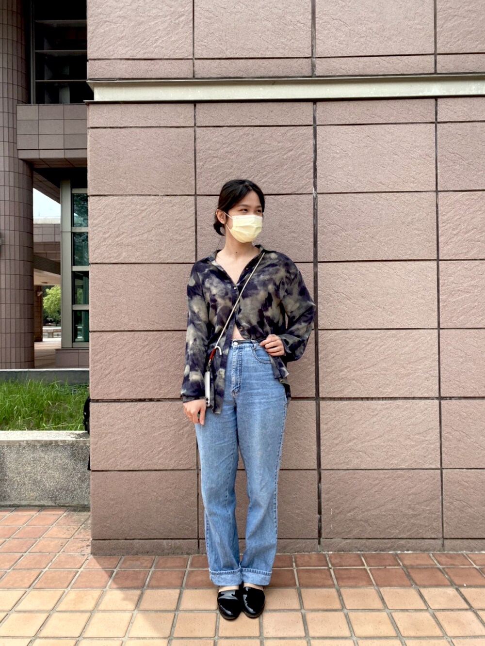 ブラック系のドレスシューズ、ブルー系のデニムパンツを着用したレディースの春コーディネートの2枚目の写真