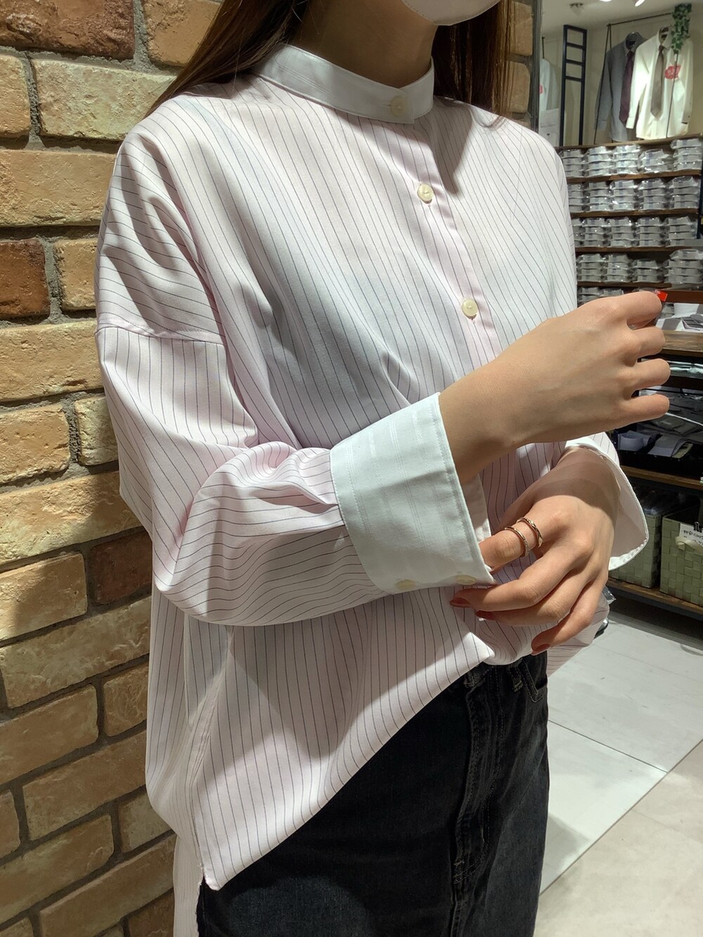 ピンク系のビジネスシャツを着用したレディースの春コーディネートの2枚目の写真