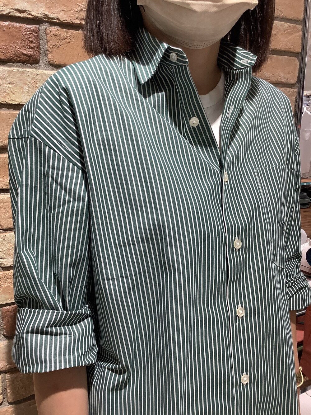 グリーン系のシャツ/ブラウスを着用したレディースの夏コーディネートの2枚目の写真