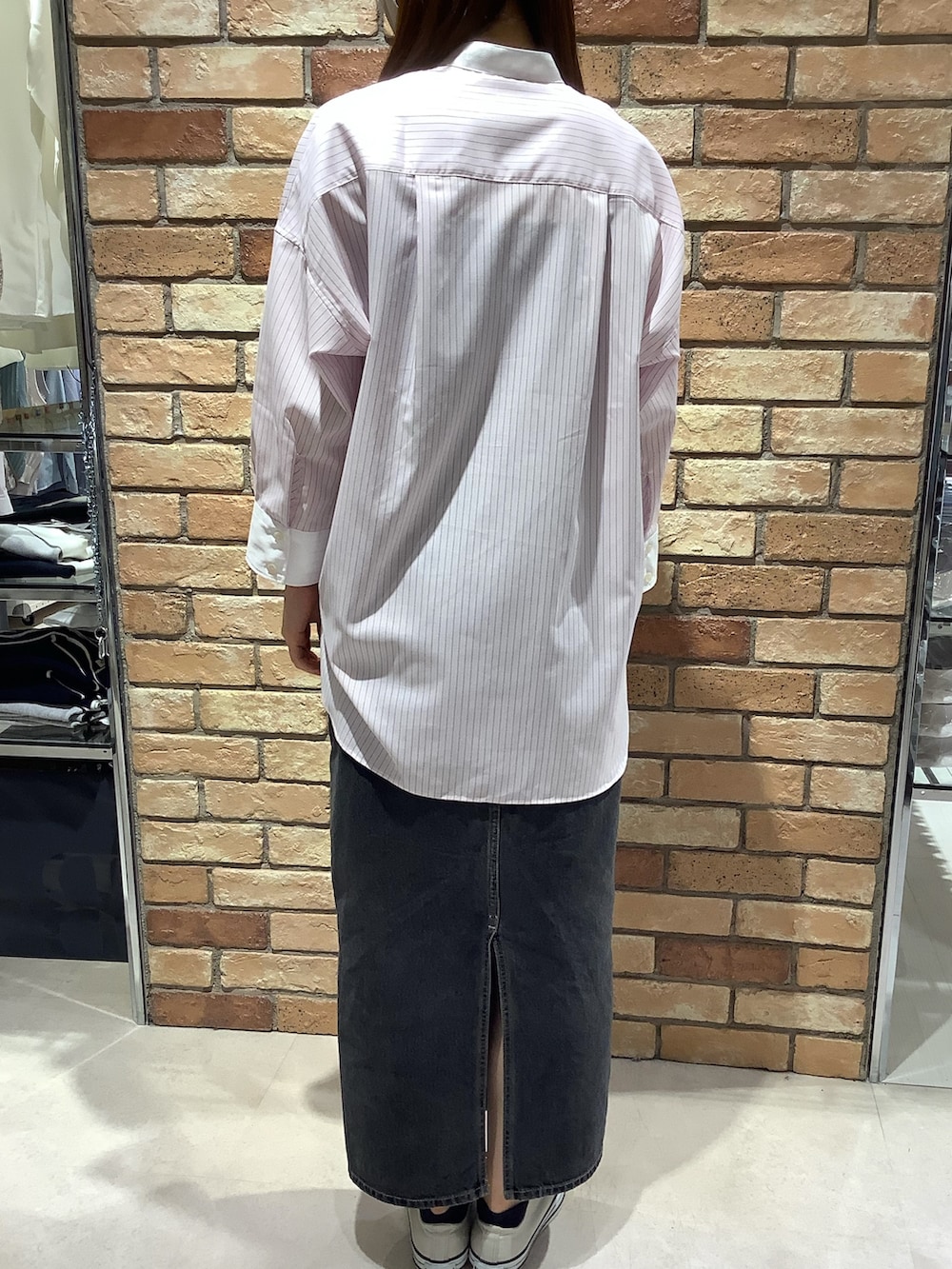 ピンク系のビジネスシャツを着用したレディースの春コーディネートの3枚目の写真