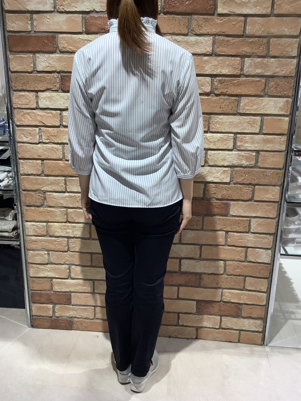 ブルー系のビジネスシャツを着用したレディースの春コーディネートの3枚目の写真