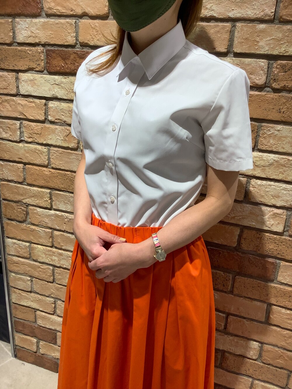 ホワイト系のビジネスシャツを着用したレディースの夏コーディネートの2枚目の写真